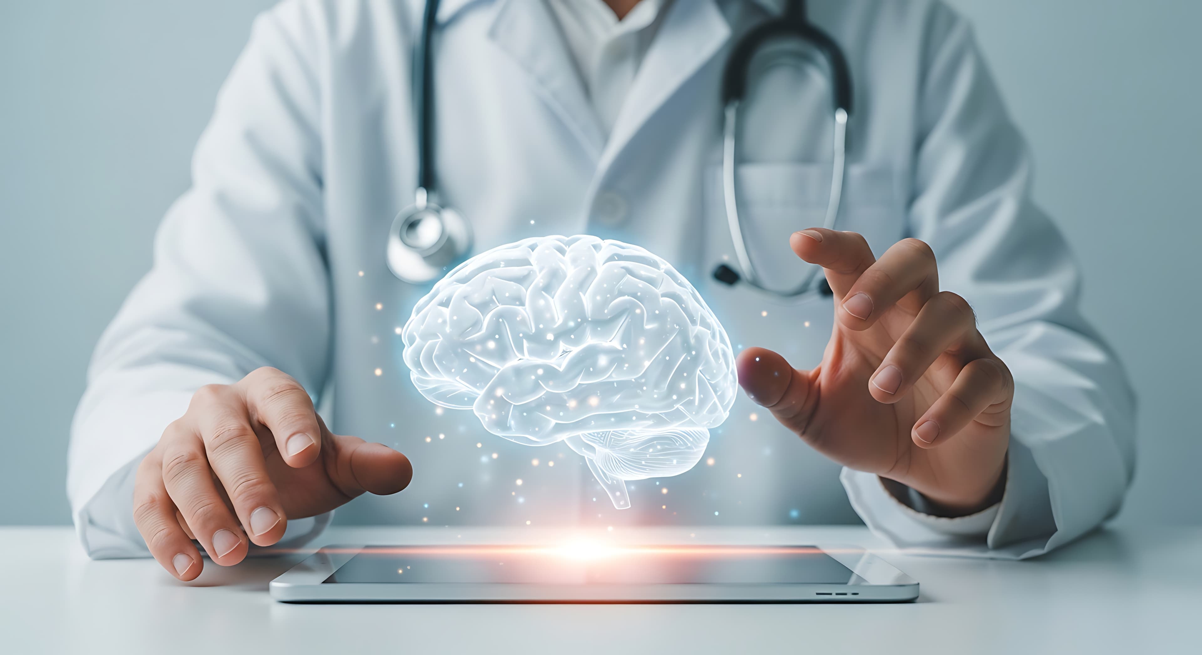 A clinician gesturing toward a softly glowing illustration of a brain above a tablet