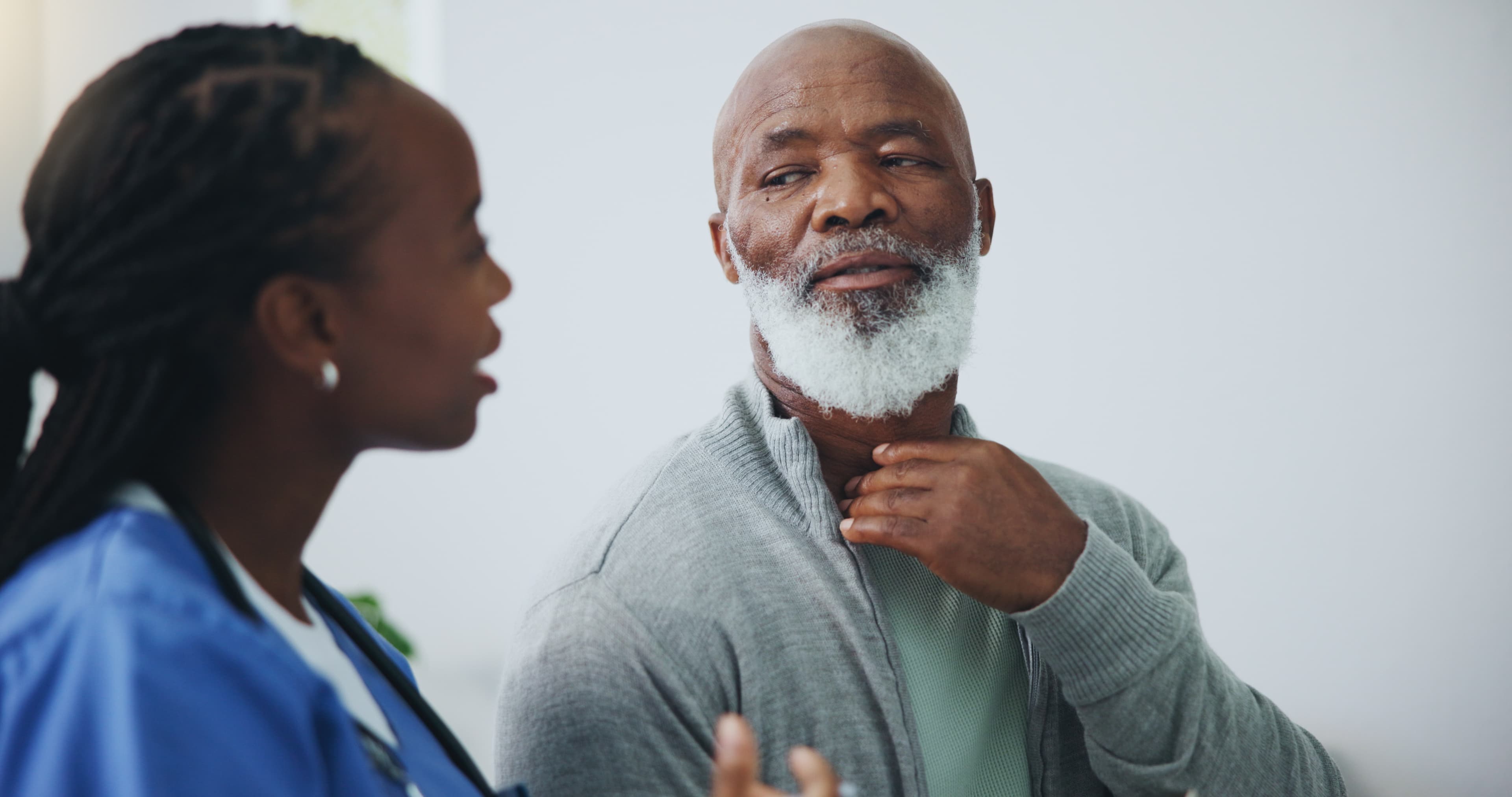 A clinician talking one-on-one with an older man during a care visit