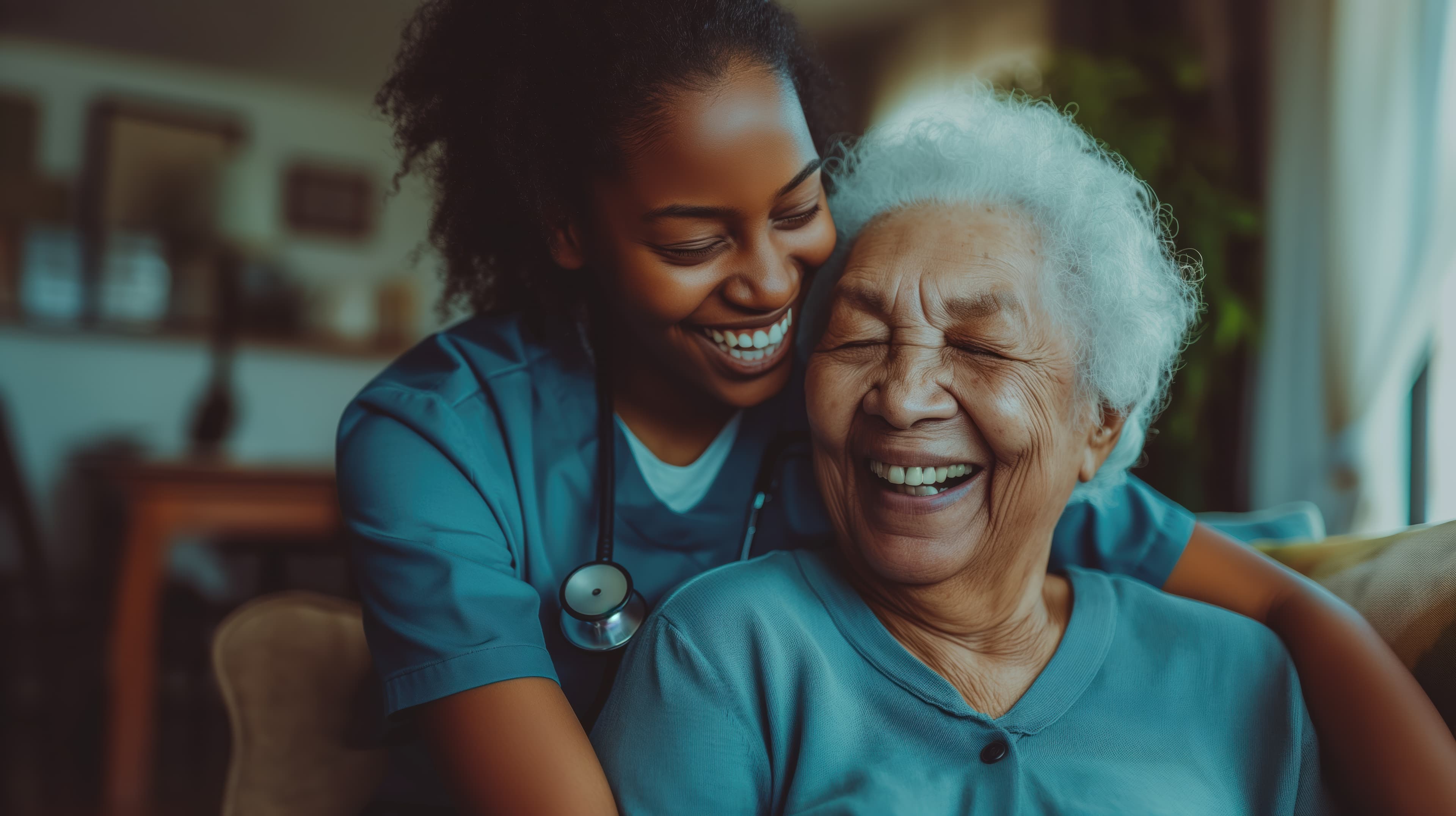 A home-care nurse hugging a laughing older woman in her home